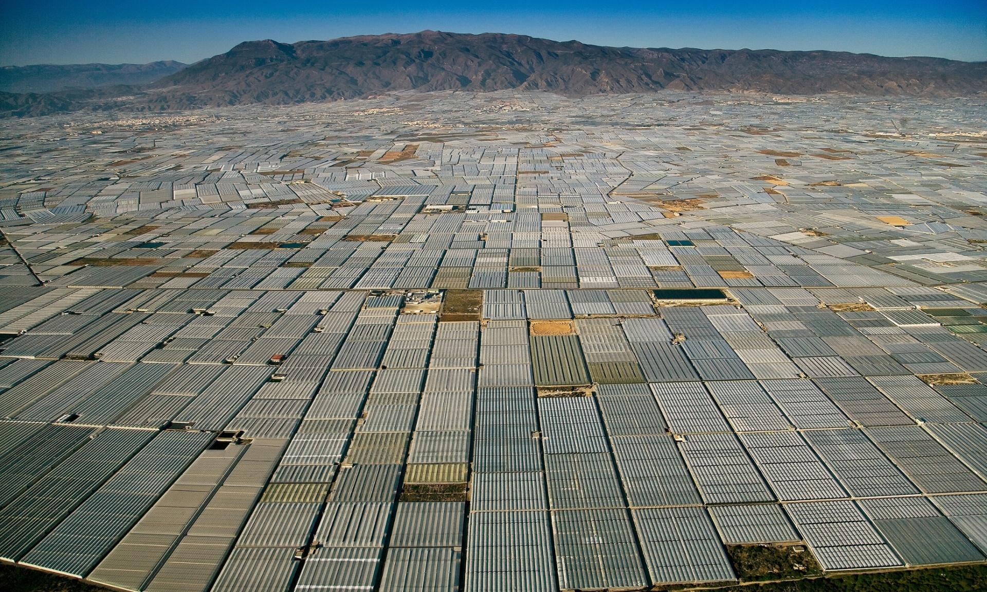 The meme is a picture of a massive, sprawling city of identical, windowless, grey concrete buildings stretching out to the horizon. The text overlay reads: "When you finally get to your destination but it's just a never-ending sea of IKEA warehouses".