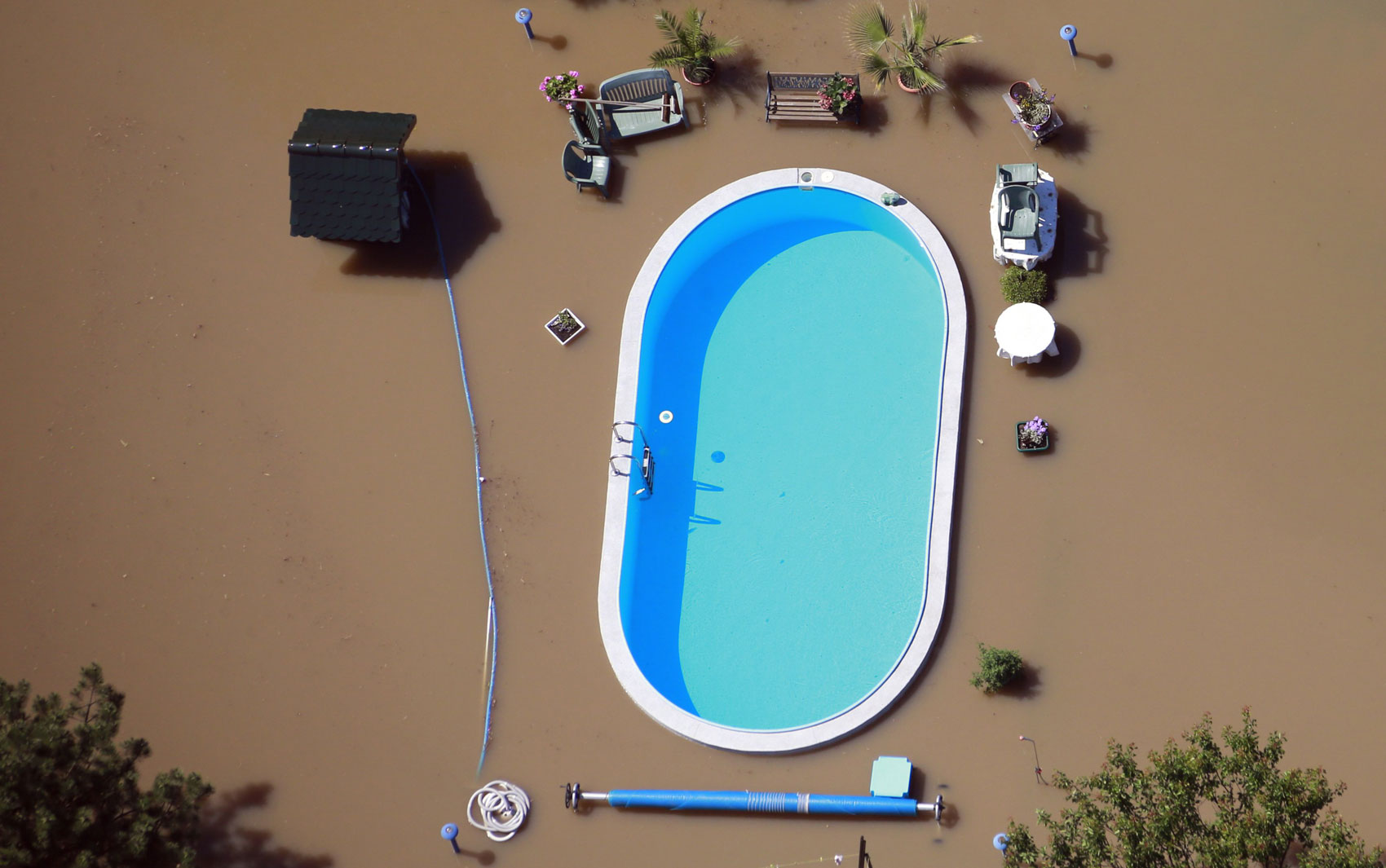 The meme is a photo of a flooded backyard with a pool that's still filled with water, but the water level is so high that it's almost overflowing. The text "I'm not lazy, I'm just conserving energy" is overlaid on the image, implying that the person is taking a leisurely approach to dealing with the flood. The image is humorous because it's a tongue-in-cheek way to describe a common excuse for not doing something, but in this case, it's a literal situation.