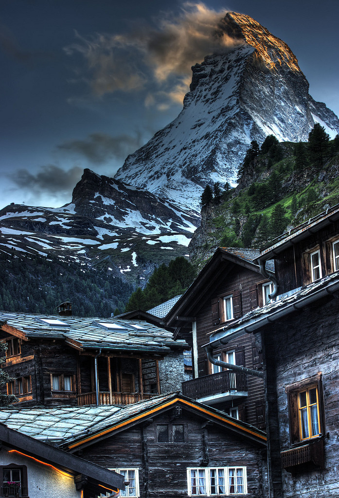The meme is a humorous image of the Swiss mountain village of Zermatt, with a small chalet-style building in the foreground and the majestic Matterhorn mountain towering above it. The image is captioned "When you finally get a good Wi-Fi signal in the mountains".