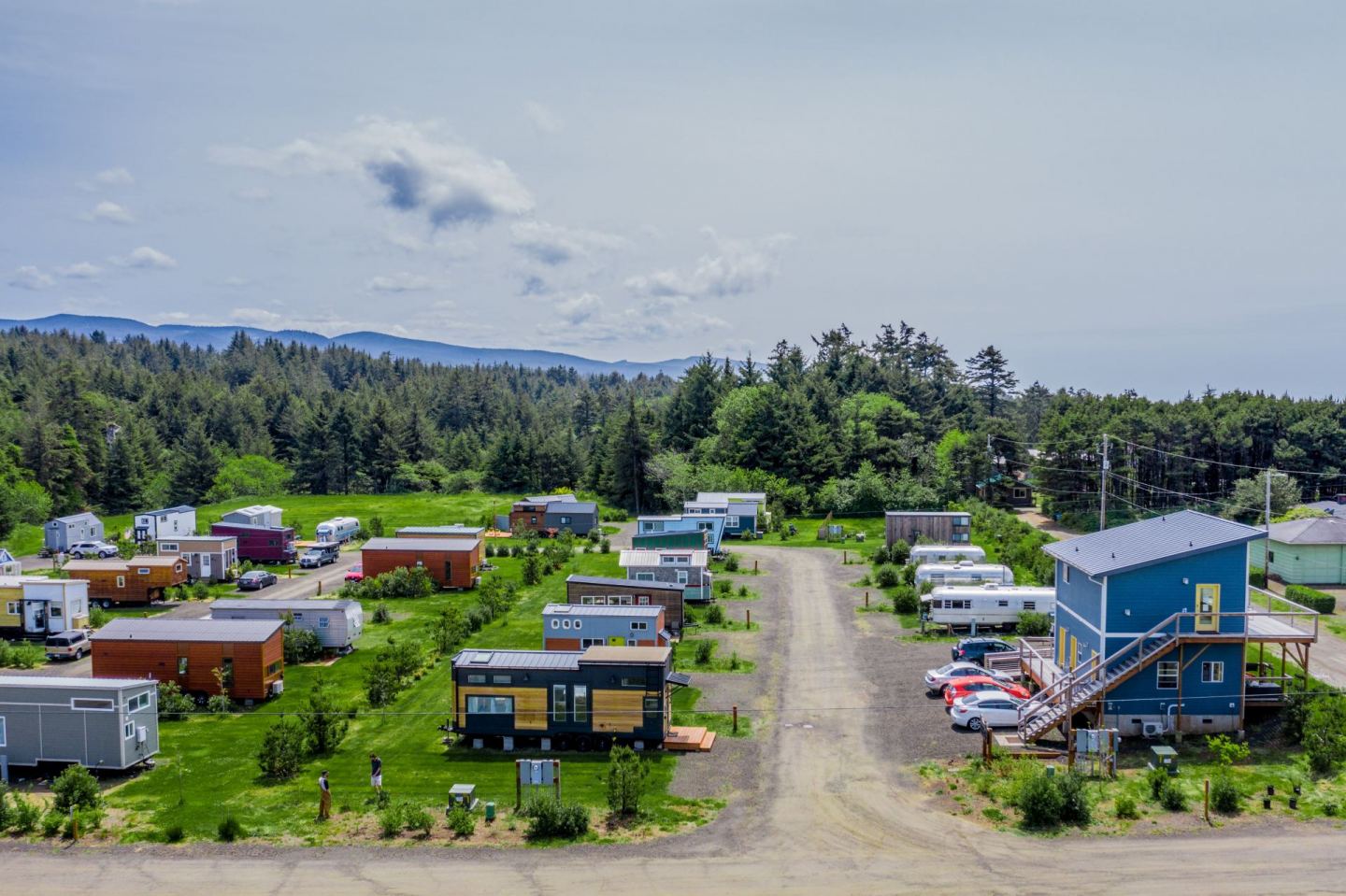 The meme is a photo of a small village of tiny houses, with a caption that says "permaculture village: where we don't have to worry about our neighbors being loud because they're already living in a shipping container...