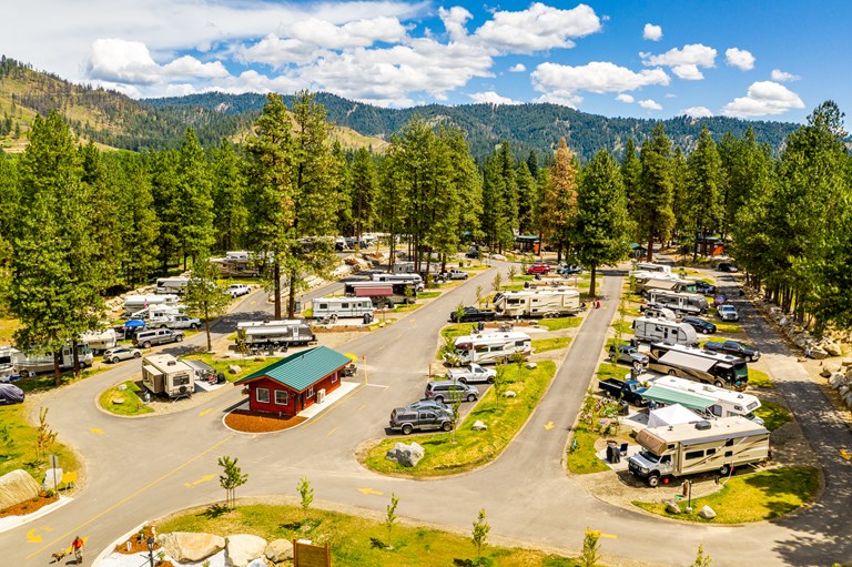 The meme is a photo of a bustling campground with RVs and campers spread out among the trees. The image is captioned "Permaculture - Shelter" and shows a mix of RVs, campers, and tents nestled among the trees, with a...