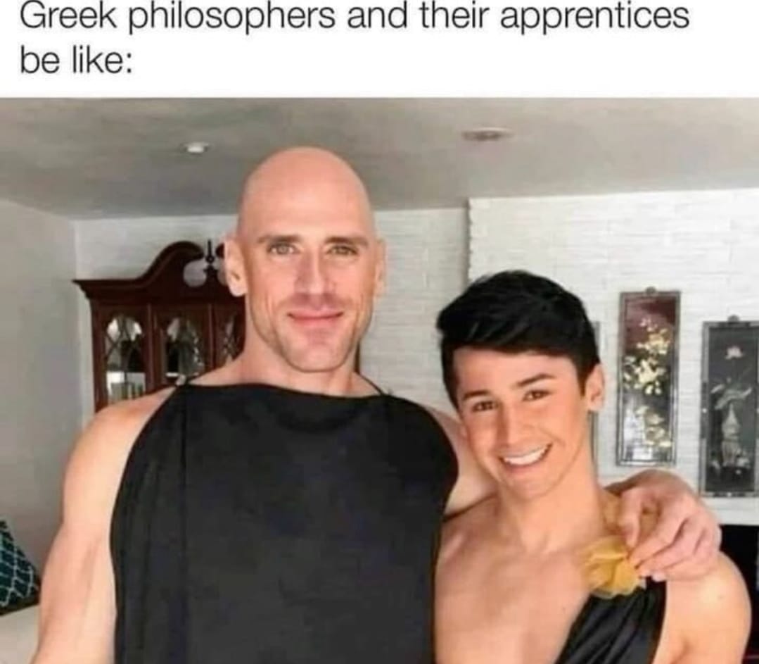 This meme is a humorous image of two people, one of whom is dressed as a ancient Greek philosopher (Aristotle) and the other as a young boy (a "philosopher" from ancient Greece). The text "Greek philosophers and their apprentices" appears above the image. The meme is poking fun at the idea that ancient Greek philosophers had young apprentices who were likely just as wise and knowledgeable as their mentors.