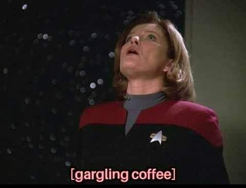 This meme is a screenshot from the TV show Star Trek: The Next Generation, featuring the character Deanna Troi with a shocked expression. The image is captioned with the phrase "I'm reading your mind and I'm getting a lot of coffee" in a bold, playful font. The meme is a humorous take on the character's ability to read minds, with the added twist of a coffee craving.