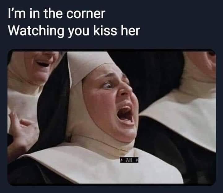 This meme is a screenshot from the TV show "The Good Place" featuring a character, Chidi, in a shocked expression. The text overlayed on the image reads "I'm in the corner, watching you kiss her" in a mocking tone, implying that someone is secretly observing a romantic moment. The image is humorous and relatable, poking fun at the idea of being a nosy observer.