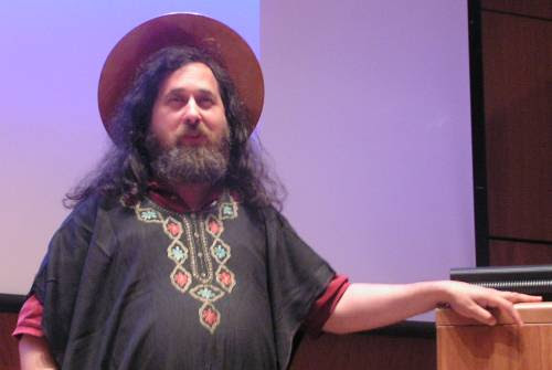 The meme is a screenshot of a man with a puzzled expression, wearing a hat and a beard. He is standing in front of a whiteboard, with a faint outline of a cat in the background. The text "I can explain why cats are drawn to this" appears on the whiteboard.