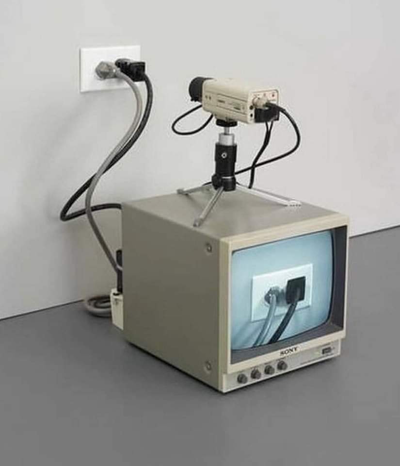 The meme is a photo of a 1980s-era computer with a built-in camera, but the camera is being used to take a picture of the computer's own monitor. The text in the image reads "I just spent 10 minutes adjusting the camera and it turns out I was just filming my screen the whole time".