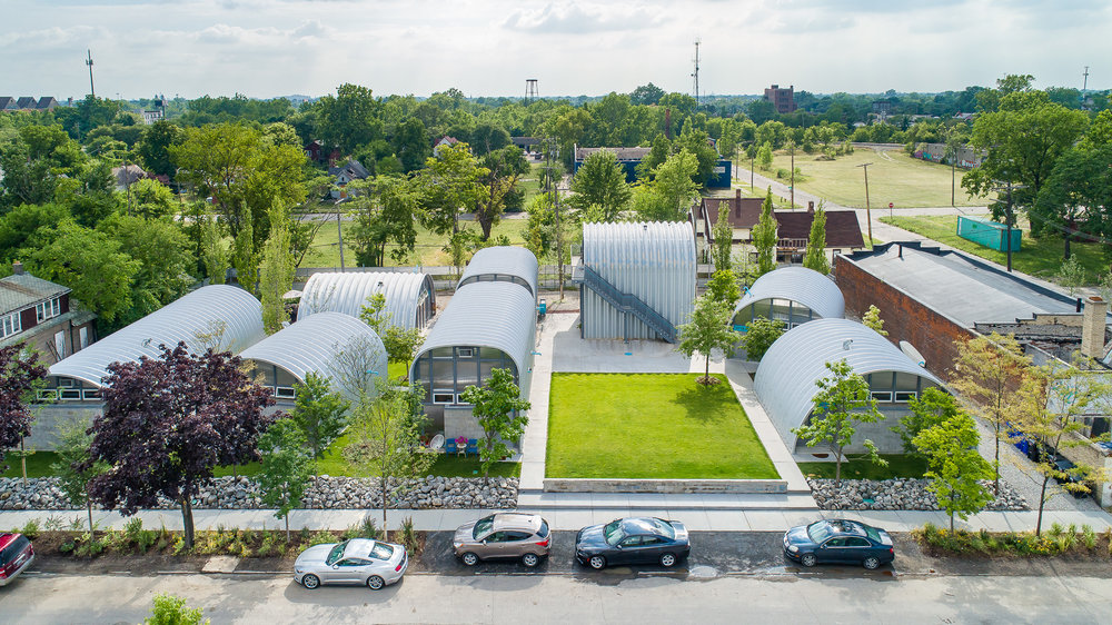 This meme is an image of a small, colorful, and seemingly abandoned apartment building. The building appears to be surrounded by a lush, green garden and has a cheerful, whimsical feel to it.