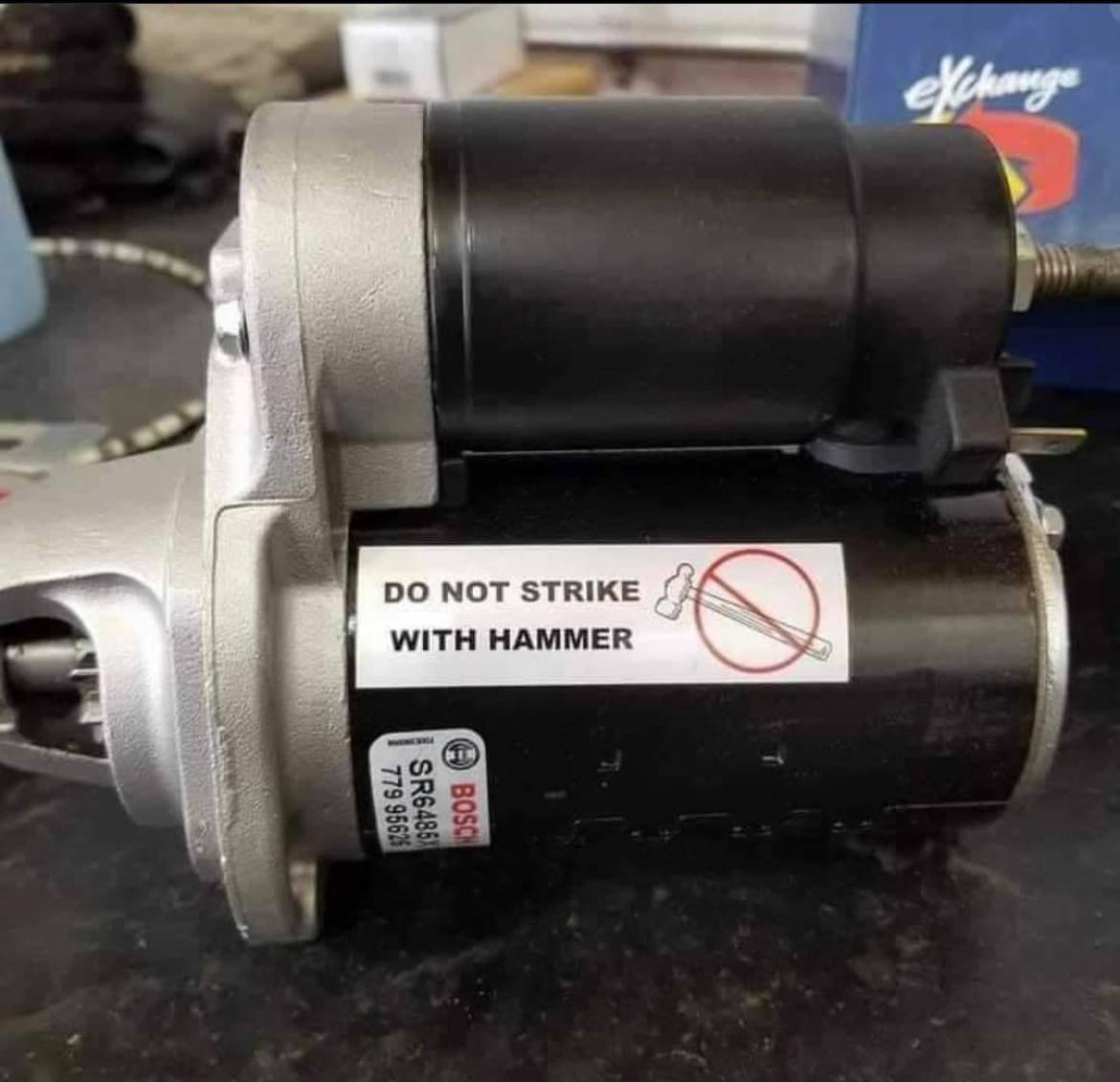 The meme is a picture of a warning label that might be found on a power tool or other machinery. The label says "Do not strike with hammer" and features a drawing of a hammer being used to strike an anvil, with a red "X" marked through it. The label is humorous because it's a warning about something that's obvious, and the image is meant to be ironic or silly.
