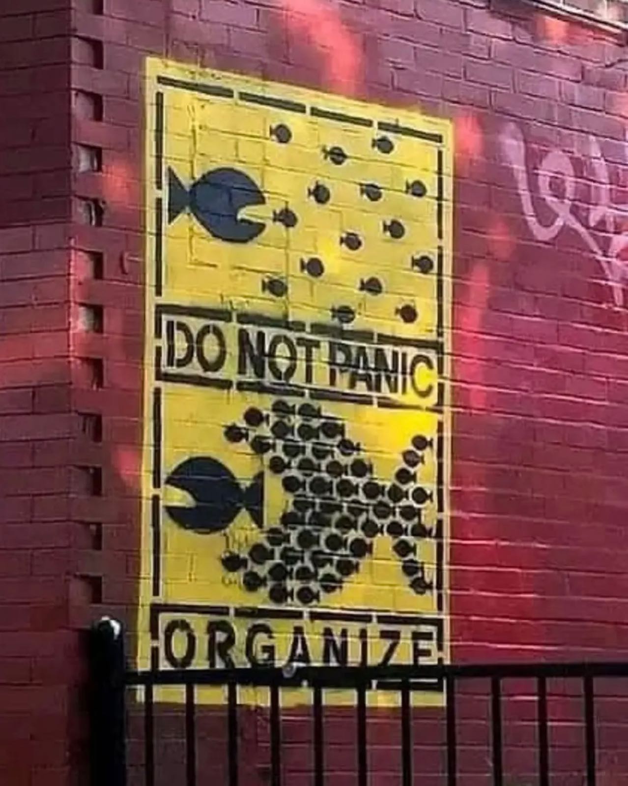 The meme is a picture of a warning sign, but it's been altered to feature a cartoonish image of a fish with a worried expression, instead of the usual "beware of the leopard" or "watch out for the snake" illustrations. The text at the top of the sign reads "Do Not Panic" and the bottom reads "In Case of Emergency, Swim Away".