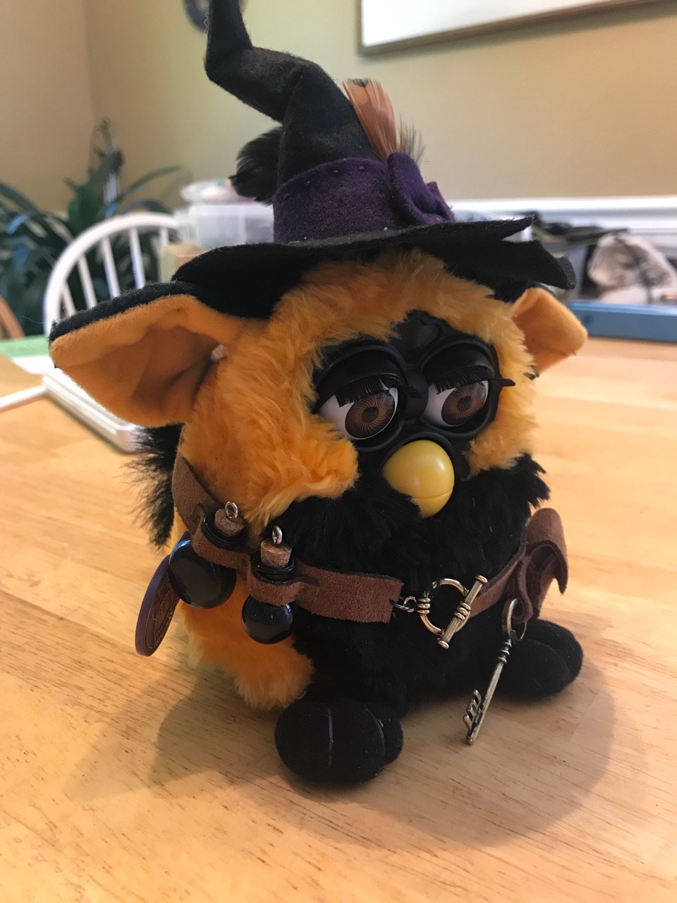 The image is a picture of a Furby, a small, electronic toy, dressed as a witch. The Furby is wearing a black and orange costume, complete with a witch's hat and a broomstick. The text "I can smell the desperation" is written above the Furby.
